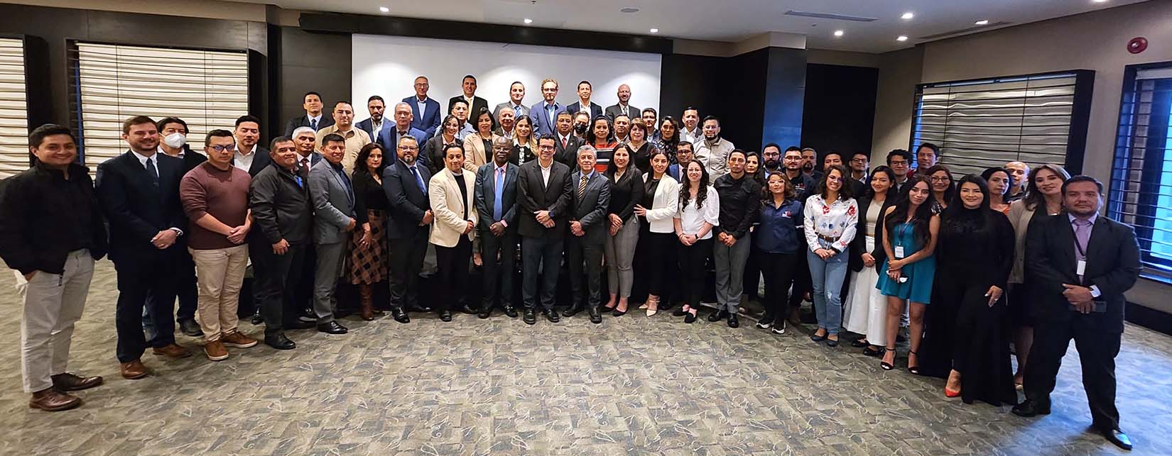 a large groupf of people pose for a photo in a conference room.